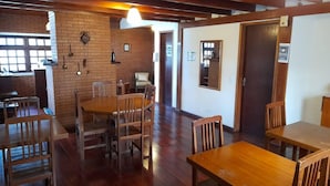 A restaurant with wooden tables and chairs, brick walls, and a wooden ceiling.