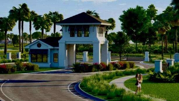 A modern building with a central tower and a smaller attached structure, surrounded by lush greenery and a curved road.