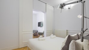 Een moderne slaapkamer met een bed, een bureau en een stoel.