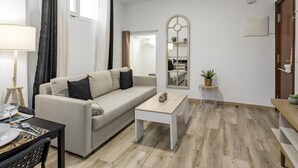 Ein stilvolles Wohnzimmer mit einer Couch, einem Couchtisch und einem Spiegel.