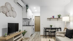Eine moderne Wohnung mit Wohnzimmer, Essbereich, Küche und einem kleinen Balkon.