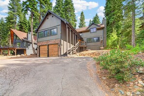 A two-story house with a stone facade, a wooden garage, and a staircase leading to a balcony. - The Seasons Tahoe 4bdr Cabin (Tahoe Vista)