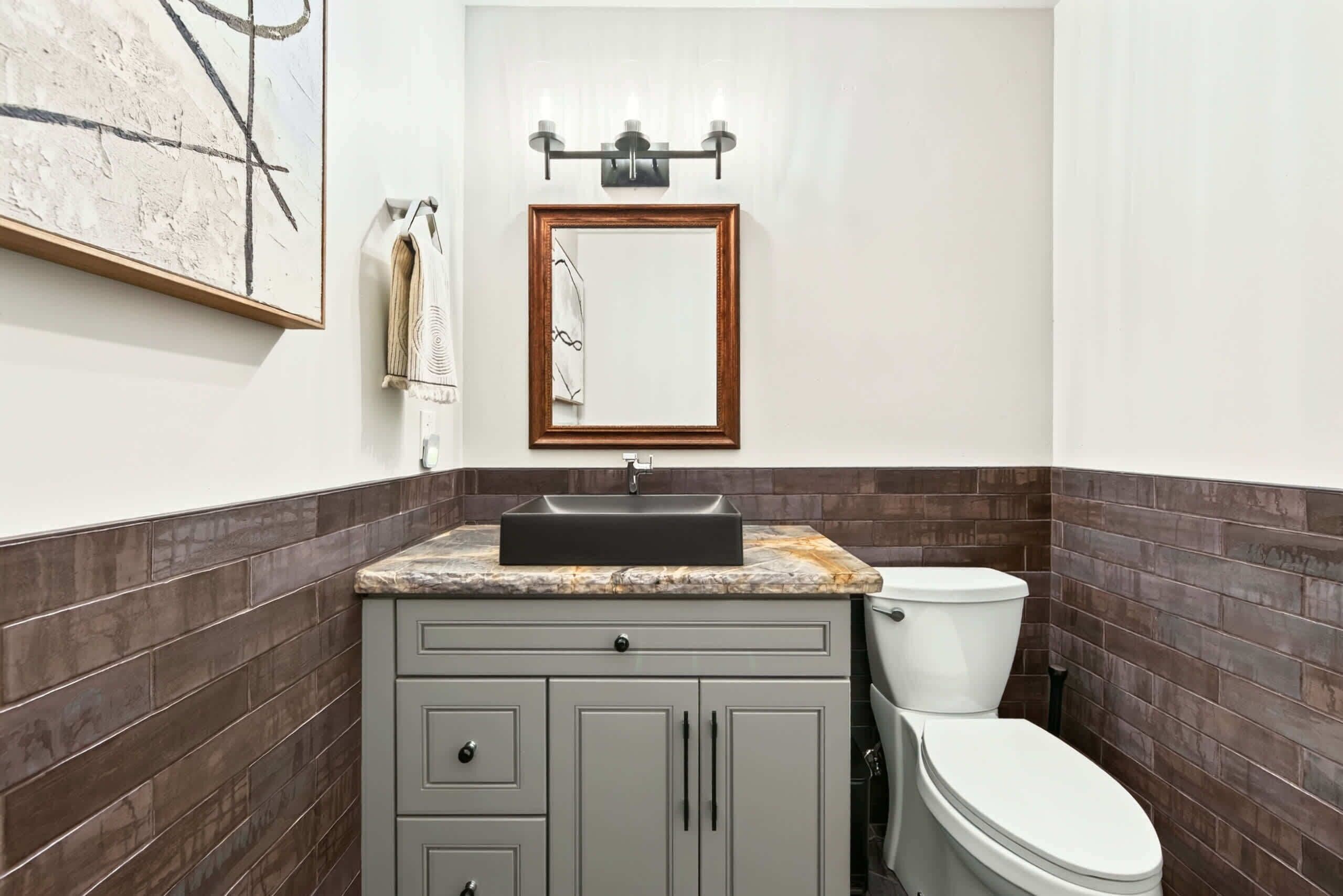 A bathroom with a sink, mirror, towel rack, and toilet.
