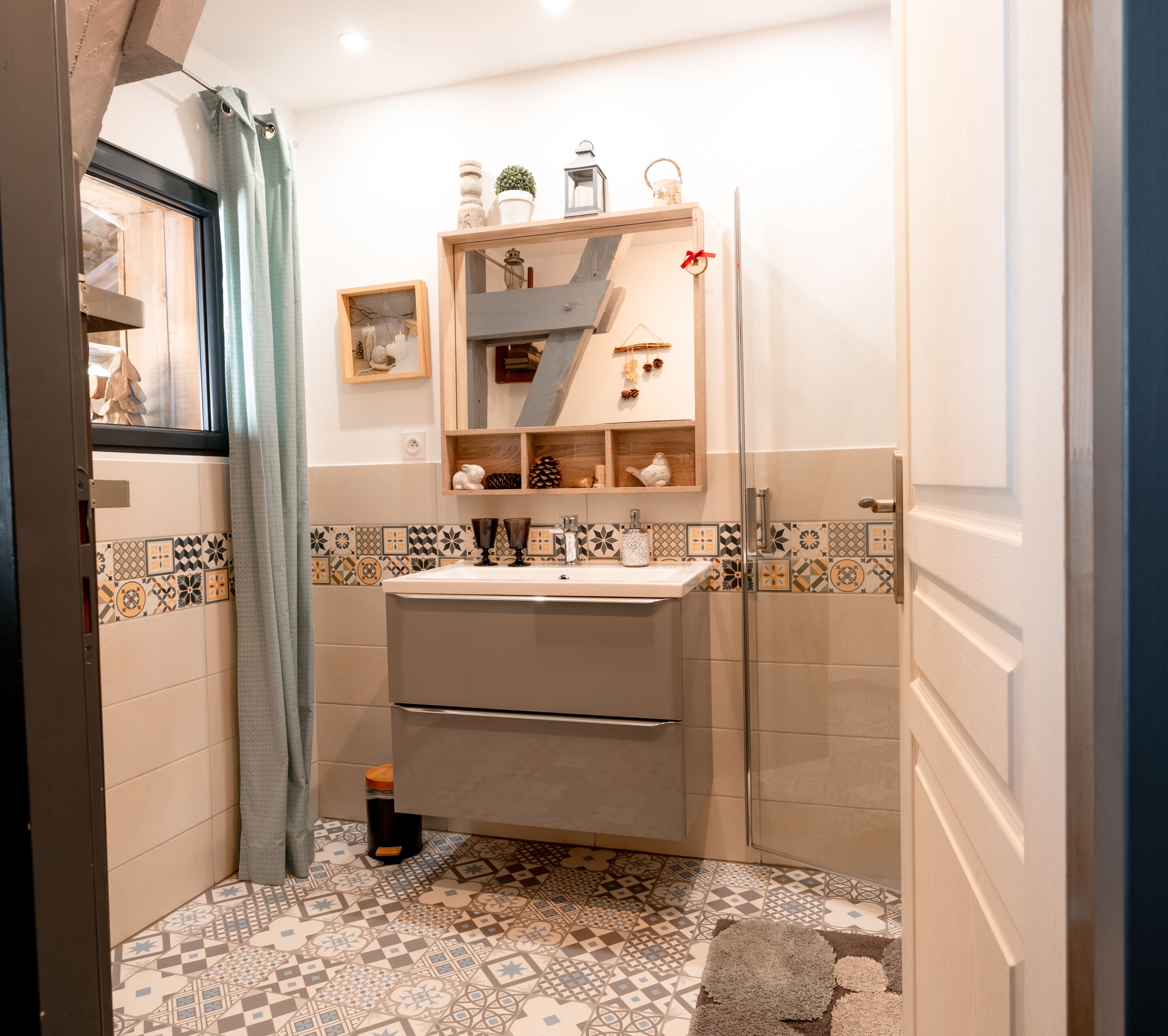 Ein Badezimmer mit Waschbecken, Spiegel und Regalen mit Dekoration.