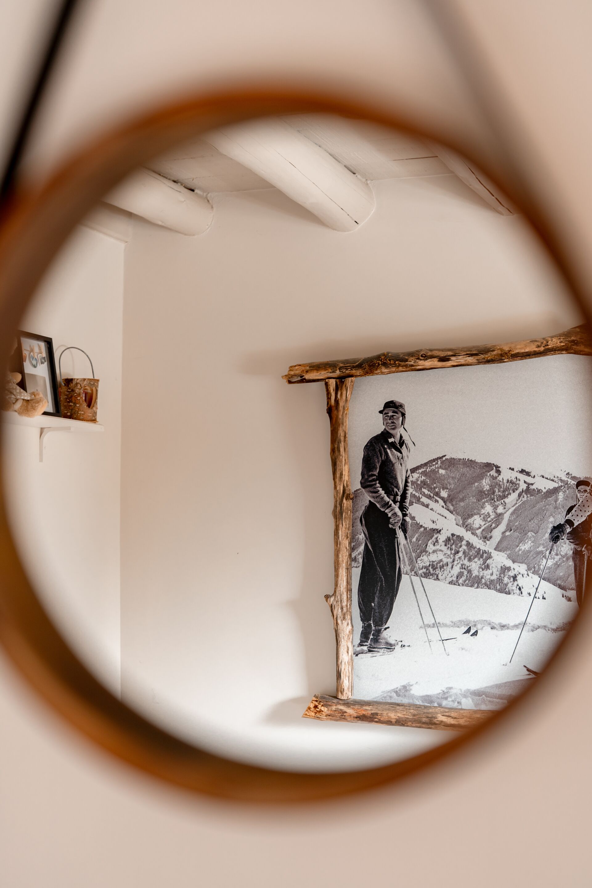 A framed photograph of a skier on a mountain, mounted on a white wall.