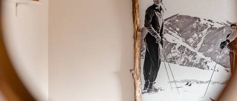 A framed photograph of a skier on a mountain, mounted on a white wall.