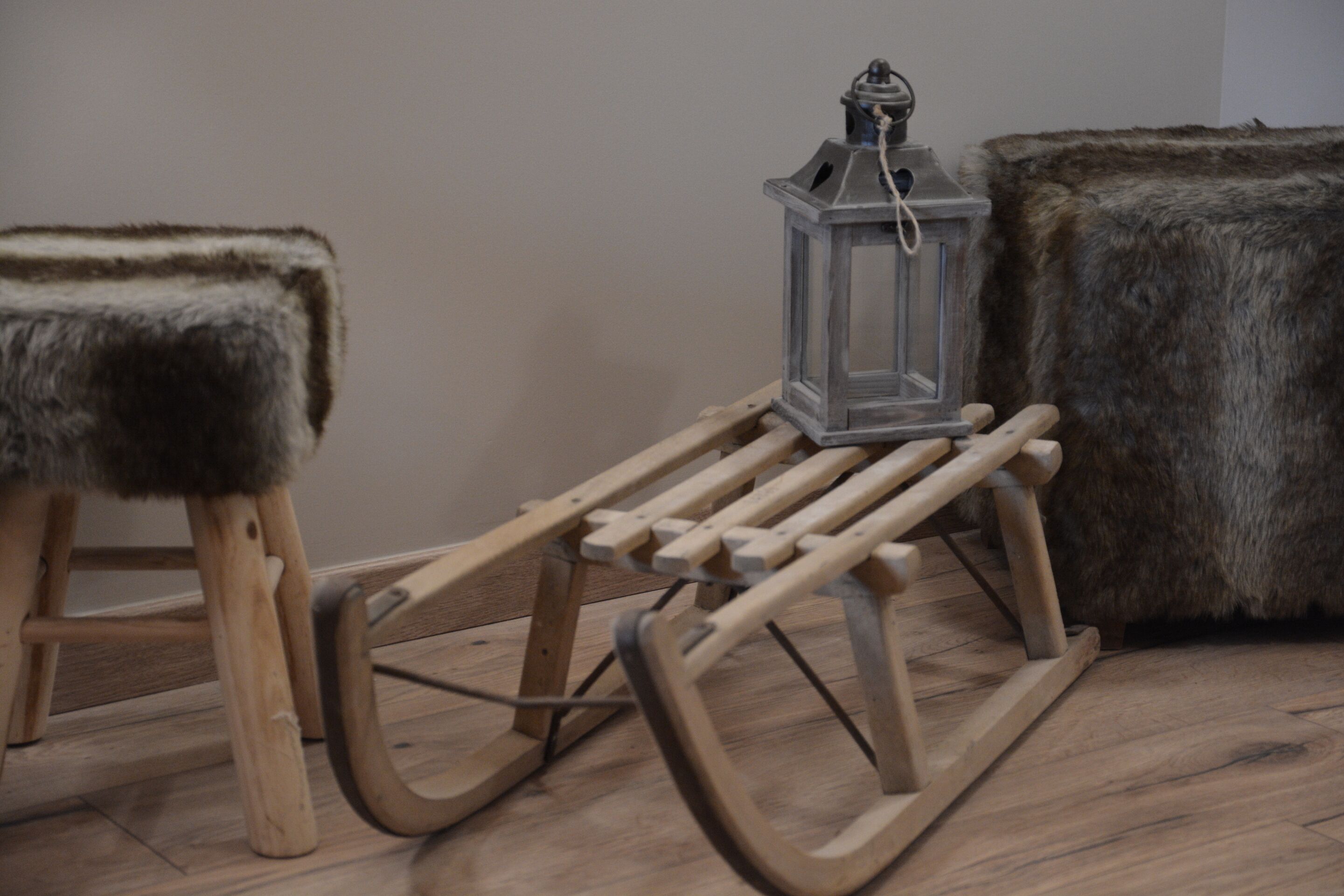 A wooden rocking chair, a small wooden table, and a fur-covered ottoman.