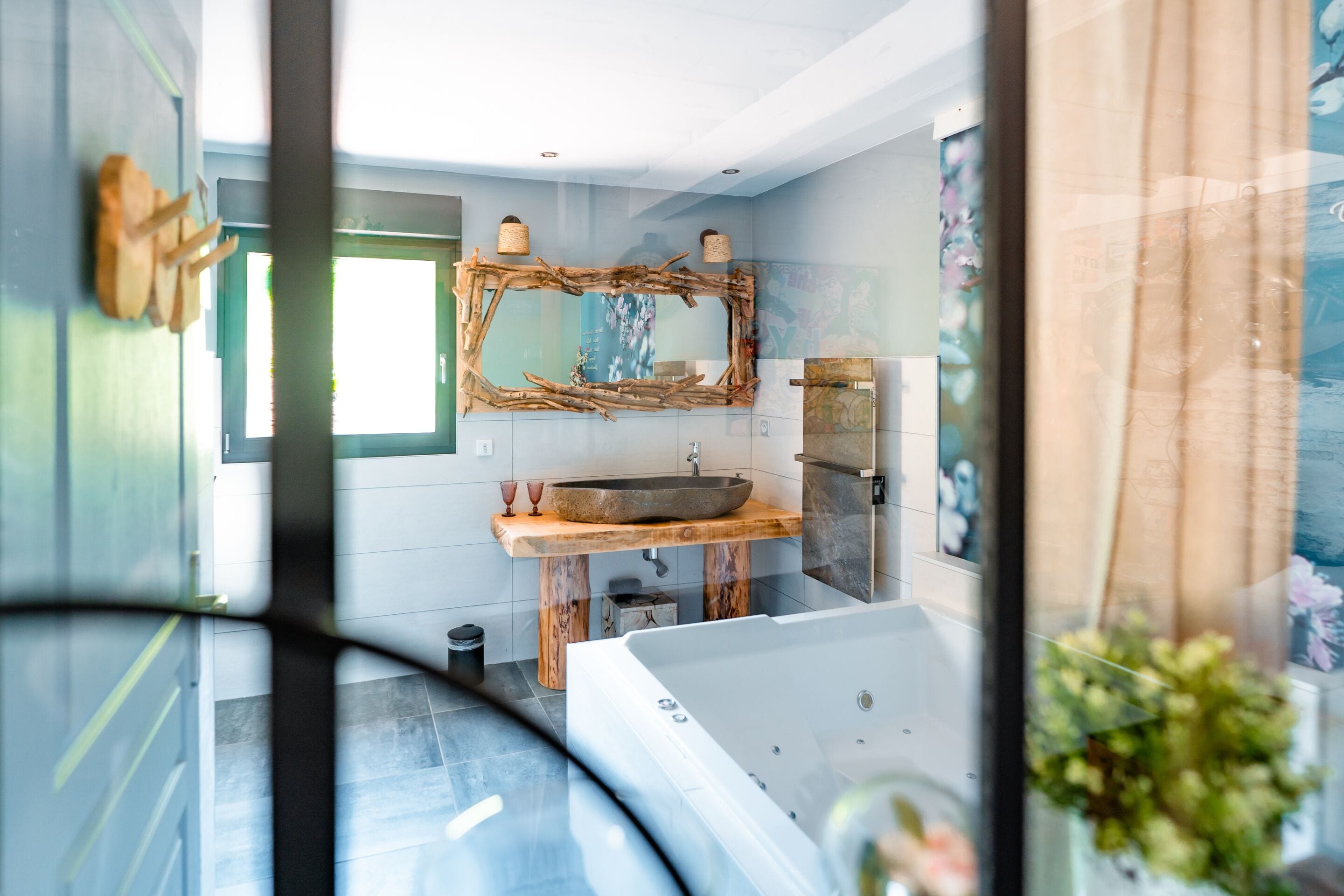 Une salle de bain moderne avec un grand miroir, un meuble-lavabo en bois et une baignoire.