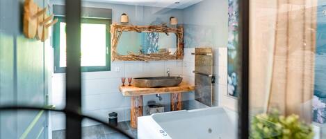 Une salle de bain moderne avec un grand miroir, un meuble-lavabo en bois et une baignoire.