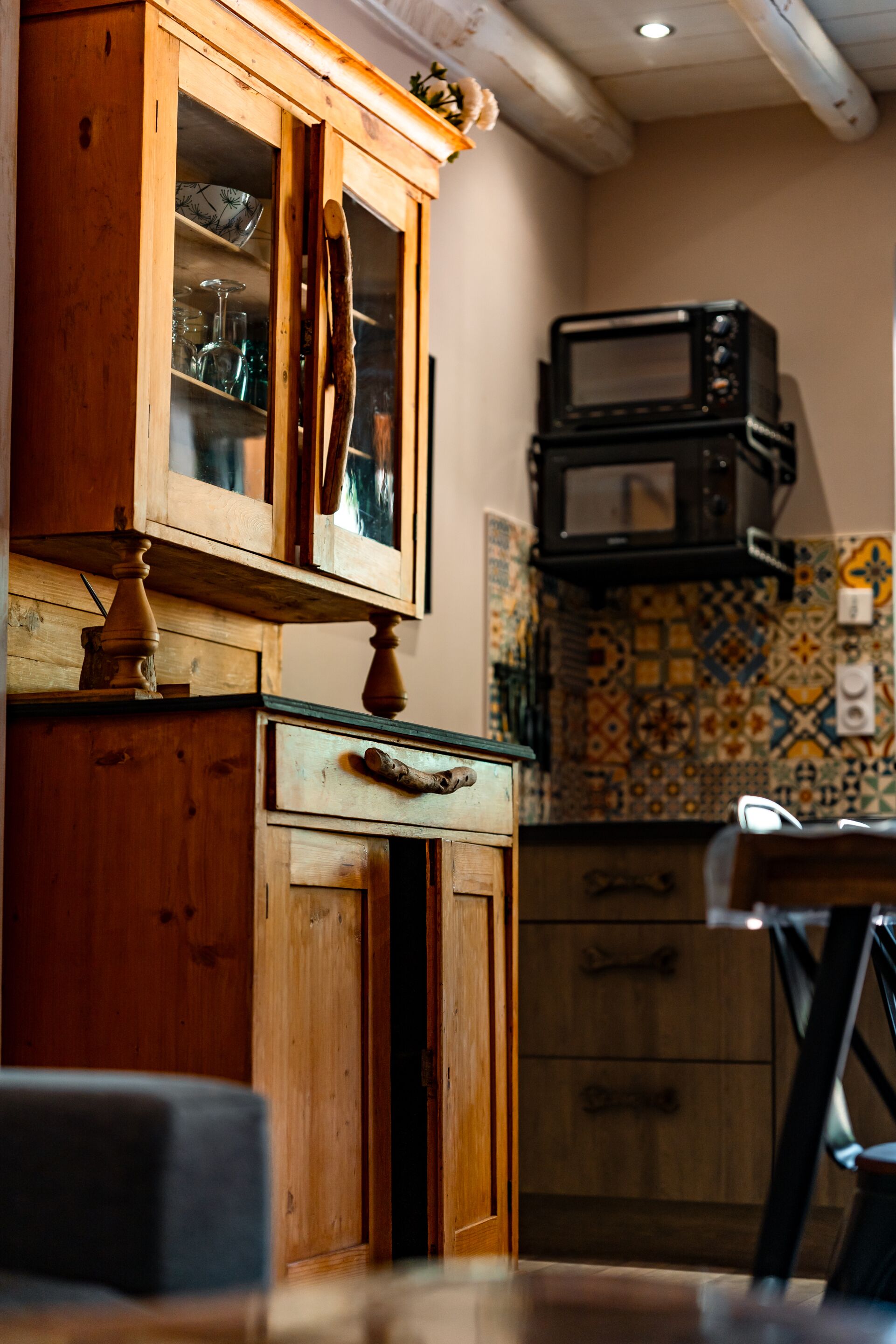 A kitchen with wooden cabinets, a microwave, and a tiled backsplash.
