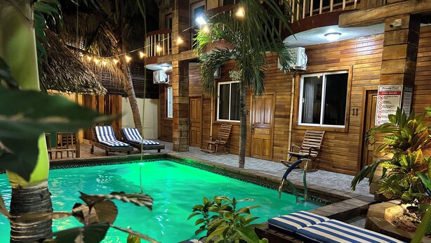 A pool area with lounge chairs and a wooden deck.