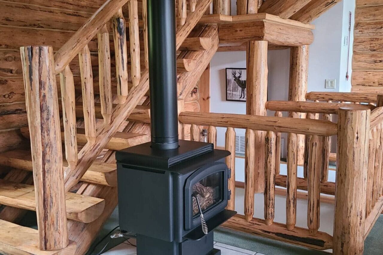 A wooden staircase with a black wood-burning stove in the center.