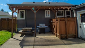 A backyard with a wooden pergola, a barbecue grill, and a picnic table. - Work away ready, dog friendly. Downtown Tillamook - Modern Vintage (Tillamook)