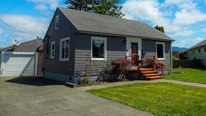 A single-story house with a front porch, a garage, and a well-maintained lawn. - Work away ready, dog friendly. Downtown Tillamook - Modern Vintage (Tillamook)