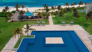 An aerial view of a resort with a large swimming pool, palm trees, and a beach. - Marea Azul Beach Resort  (Playa del Carmen)