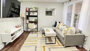 Una sala de estar moderna con un sofá gris, una mesa de centro blanca y una estantería.