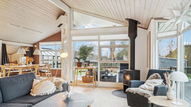 A spacious living area with a high ceiling, large windows, a fireplace, and a cozy seating arrangement. - 3 bedroom pet friendly home in Beder (Beder)