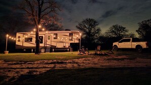 A campsite at night with a camper and a pickup truck.