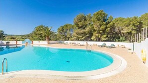 A clear blue swimming pool surrounded by lounge chairs and a white wall. - Flat Surrounded by Nature, With Pool, and Beach Nearby (Son Parc)