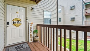 A front door with a 'hello' sign, a welcome sign, and a doormat.