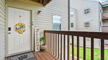 A front door with a 'hello' sign, a welcome sign, and a doormat.