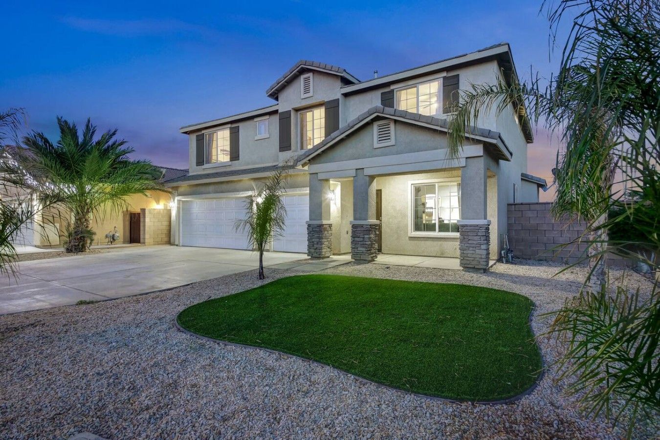 A two-story house with a garage, a well-maintained lawn, and a driveway.