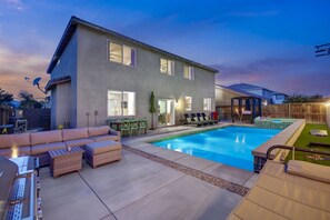 A modern two-story house with a swimming pool, outdoor seating, and a covered patio area. - Park Heaven: Pool, Spa, Fire Pit, Games, BBQ! (Coachella)