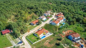 Vue aérienne d’un quartier résidentiel avec des maisons, des routes et la végétation environnante.