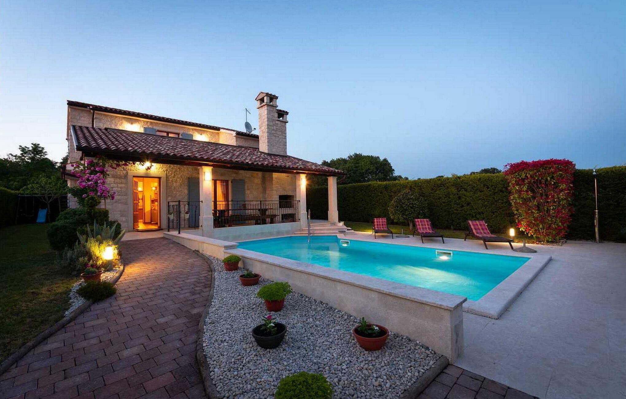 Une maison moderne dotée d’une piscine, d’un espace extérieur aménagé et d’un jardin bien entretenu.