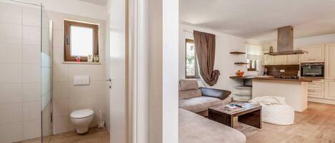 A modern apartment with a bathroom, living room, and kitchen.