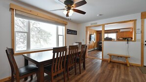 A dining area with a wooden table and chairs, a ceiling fan, and a view of the outdoors. - Osprey Point - Lakefront Dock, Kayaks & Fire Pit (Cable)
