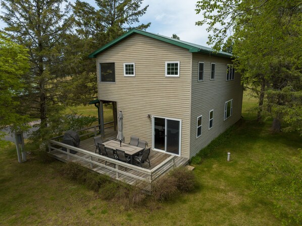 A two-story house with a deck, outdoor seating, and a covered patio area. - Osprey Point - Lakefront Dock, Kayaks & Fire Pit (Cable)