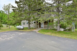 A single-story house with a porch, a large cylindrical tank, and a driveway. - Osprey Point - Lakefront Dock, Kayaks & Fire Pit (Cable)