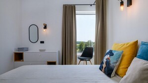 A modern hotel room with a large bed, a desk with a bowl, a chair, and a view of the outdoors. - 3 bedroom beautiful home in Porec (Porec)