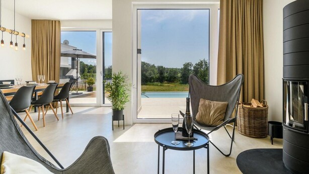 A modern living room with a dining area, a large sliding glass door to a pool, and a fireplace. - 3 bedroom beautiful home in Porec (Porec)