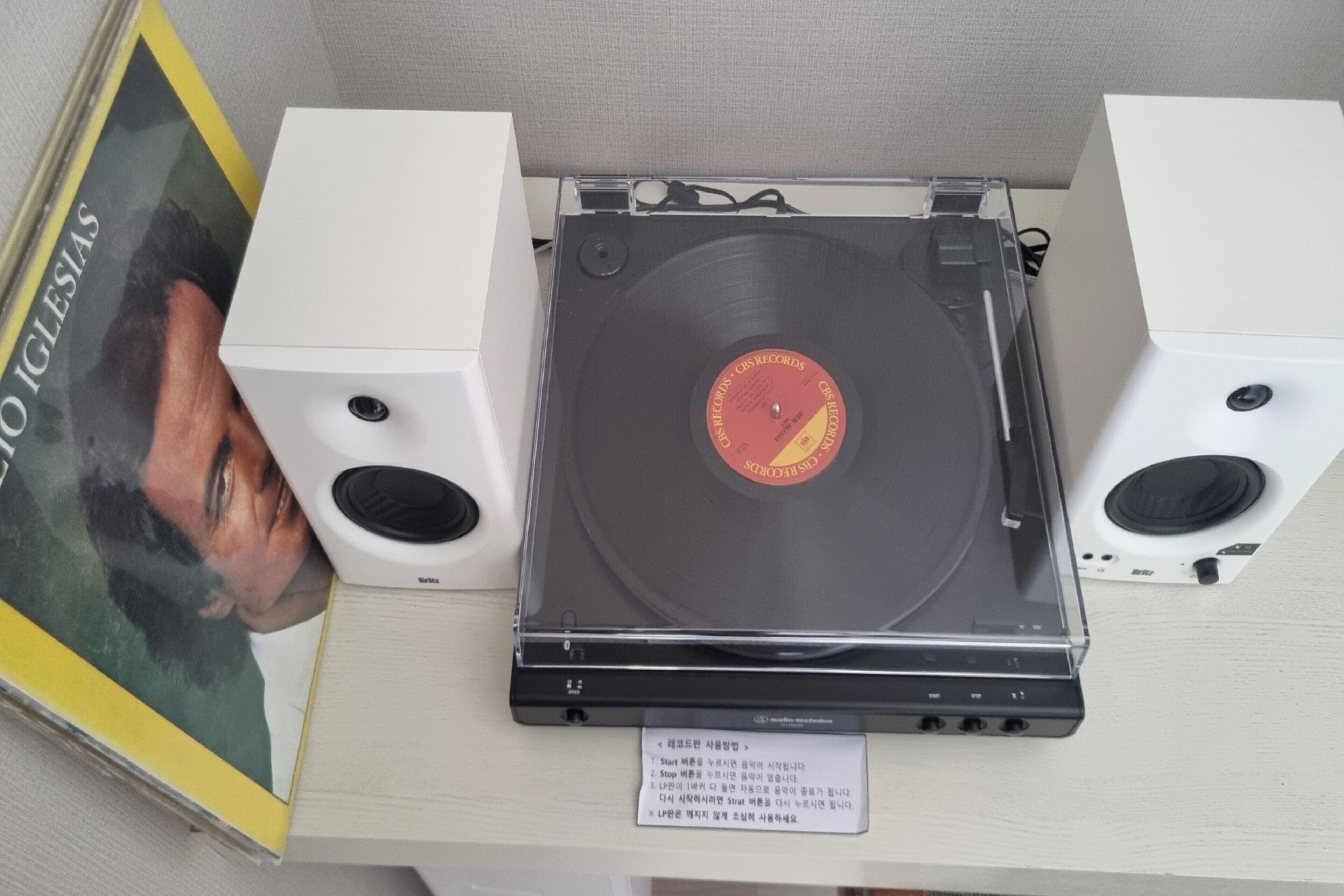Un toca discs amb un disc de vinil, dos altaveus i un cartell amb instruccions.