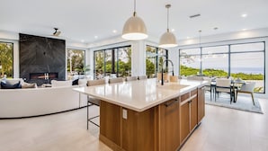 A modern kitchen with a large island, built-in appliances, and large windows offering ocean views. - Pier Pleasure - Anna Maria at it's finest! Pool, hot tub, beach, putting green (Anna Maria)
