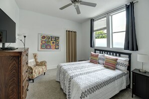 A bedroom with a bed, a chair, a dresser, a ceiling fan, a window with curtains, and a wall art piece. - 4 Bedroom flat in ideal location by upscale shops, cafes. Fast WiFi (San Francisco)