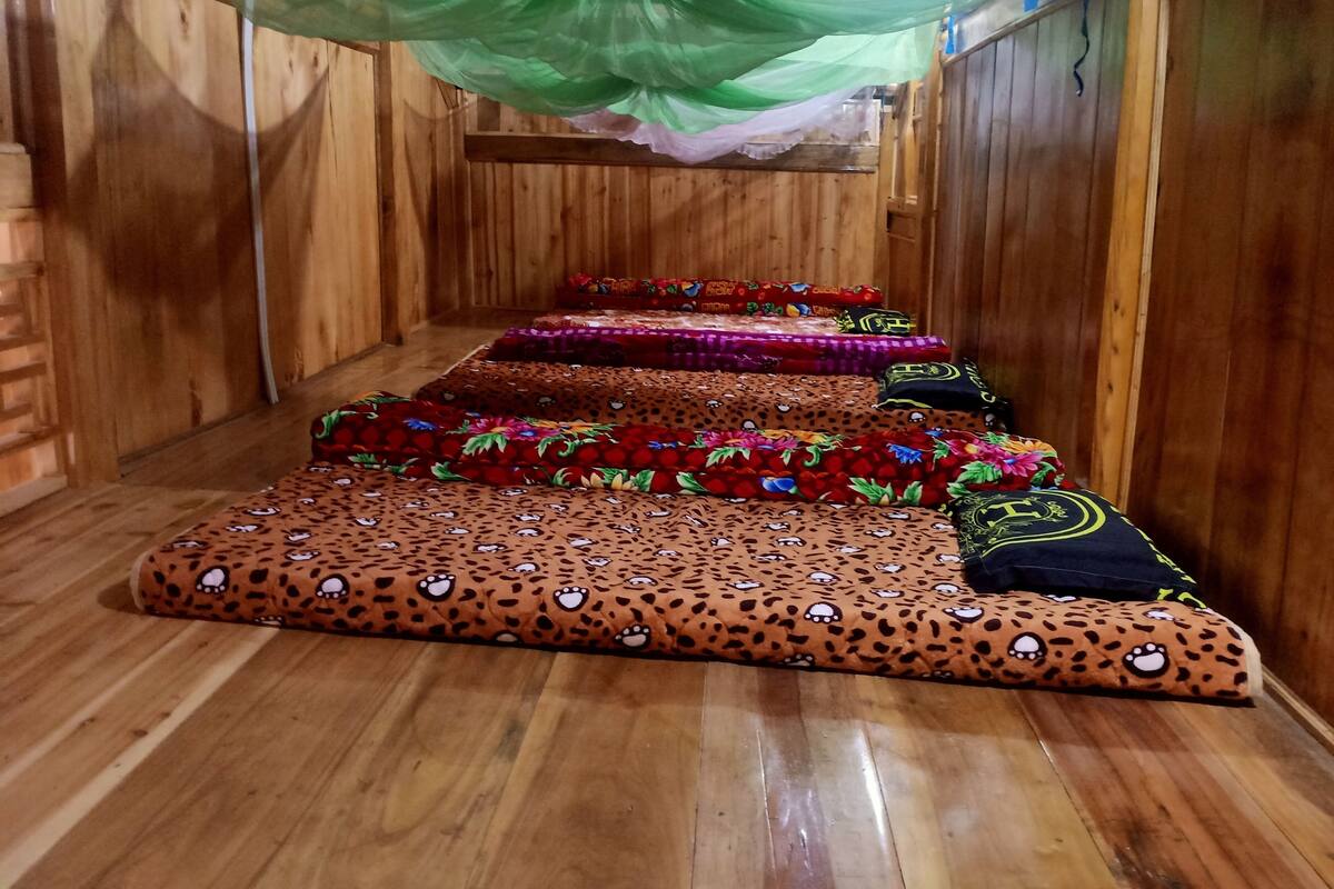 A wooden room with a series of colorful, patterned mats arranged in a row.