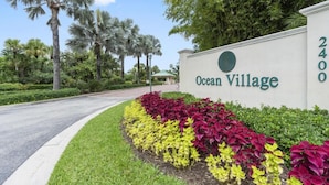 Une enseigne indiquant l’entrée d’Ocean Village, avec un jardin aménagé devant.