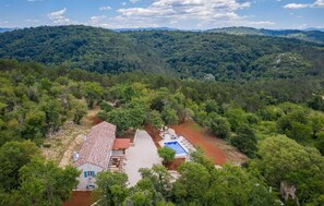 A house surrounded by dense forest with a swimming pool and a red-roofed building. - Amazing home in Oprtalj (Oprtalj)