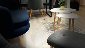 A modern living room with a sofa, a coffee table, and a dining table with chairs. - Hills Nomad Studio (București)