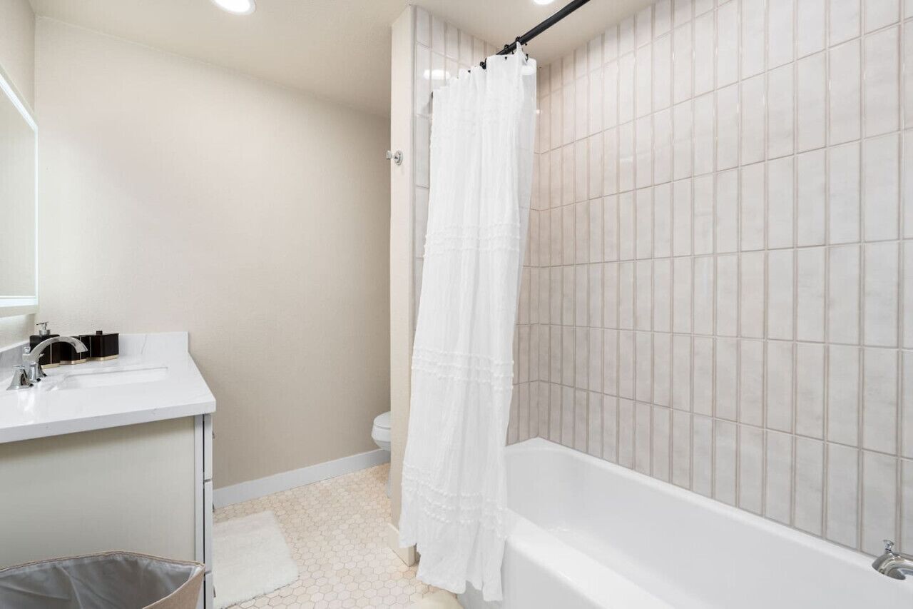 Un baño con lavamanos, inodoro y bañera blancos.