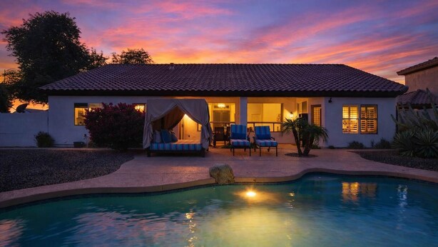 Una casa con piscina, zona relax all'aperto coperta e patio.