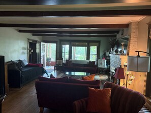 A living room with a fireplace, a sofa, a television, and a dining area with a table and chairs. - Beautiful old home with lots of character, a few blocks from downtown Prescott! (Prescott)
