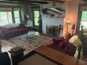 A living room with a fireplace, a sofa, a coffee table, and a lamp. - Beautiful old home with lots of character, a few blocks from downtown Prescott! (Prescott)