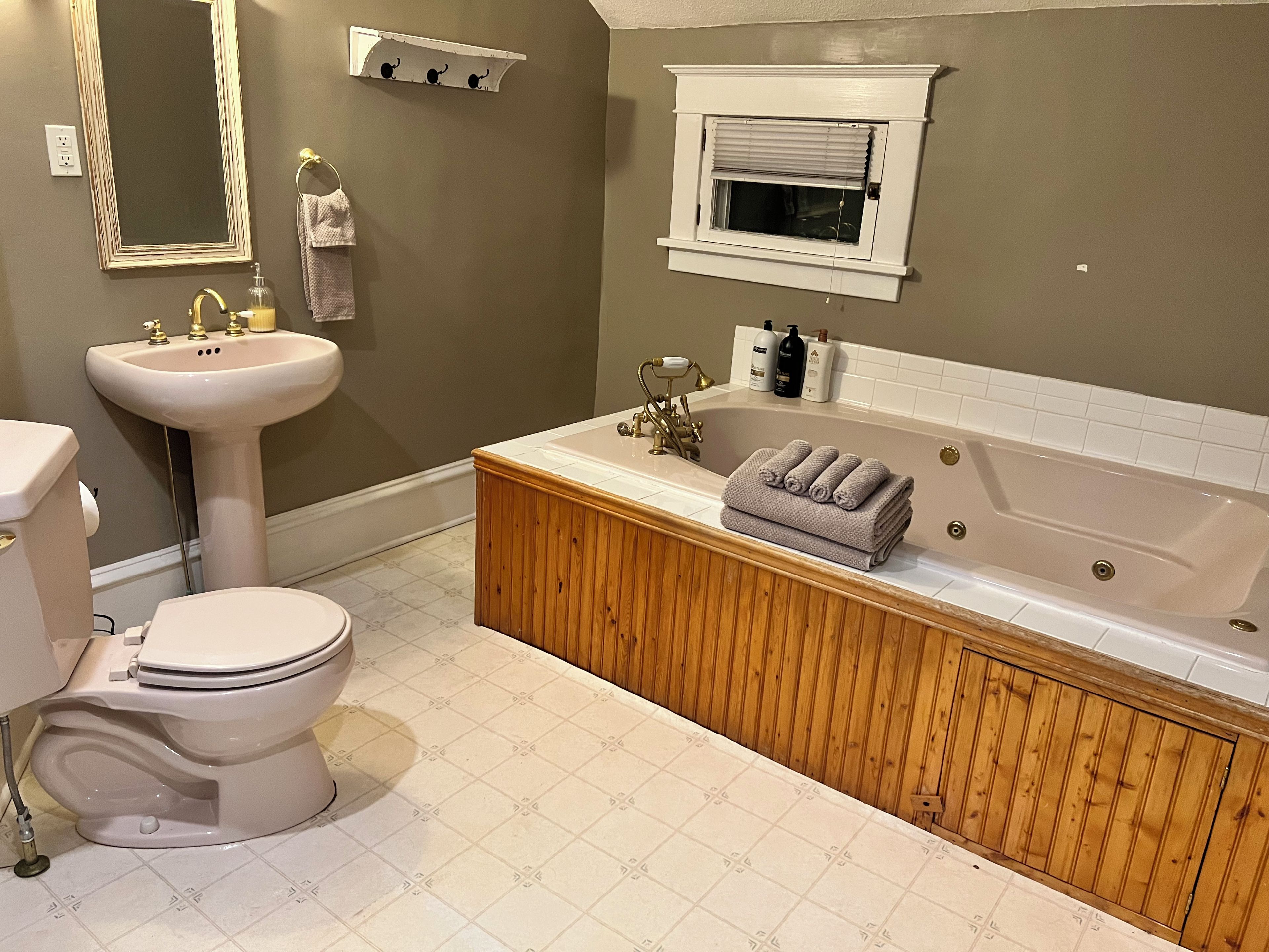 Une salle de bain comprenant des toilettes, un lavabo, un meuble-lavabo et une baignoire.