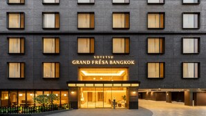 La façade d’un hôtel, ornée de nombreuses fenêtres et d’une enseigne indiquant « SOTETSU GRAND FRESK BANGKOK ».