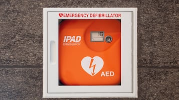 An emergency defibrillator mounted on a wall.