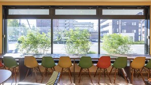 A modern interior with large windows, a long bench, and colorful chairs. - OSAKA PORT HOTEL L'ESPOIR (Osaka)